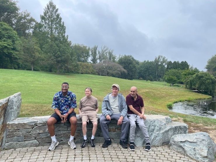 A group of Trail Trekkers participants sitting on a bench in Brookside Gardens.
