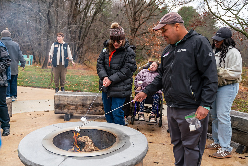 People around a campfire roasting marshmallows.