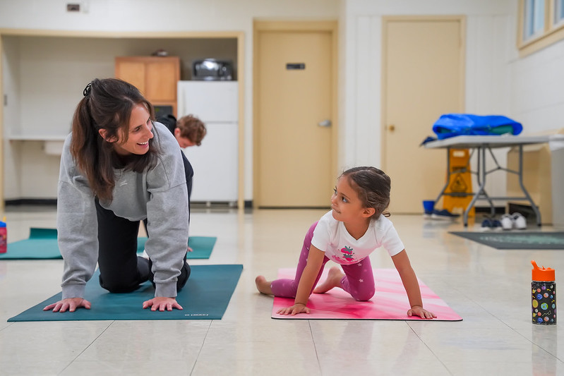 Woman and child doing table-top yoga pose.