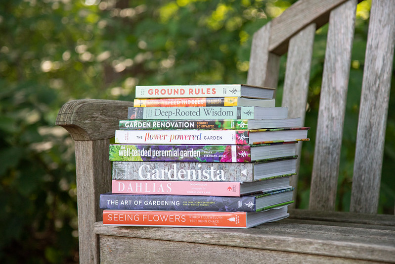stack of books on park bench 