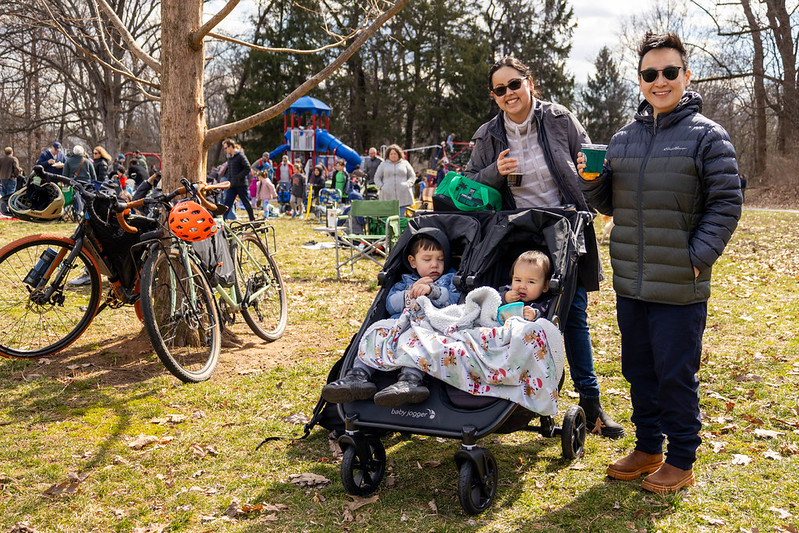 Family with 2 kids in stroller smile for camera