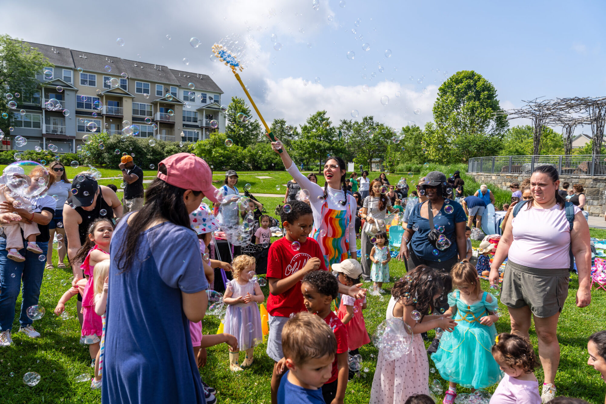 Jonna Productions holds up bubble wand as children gather around