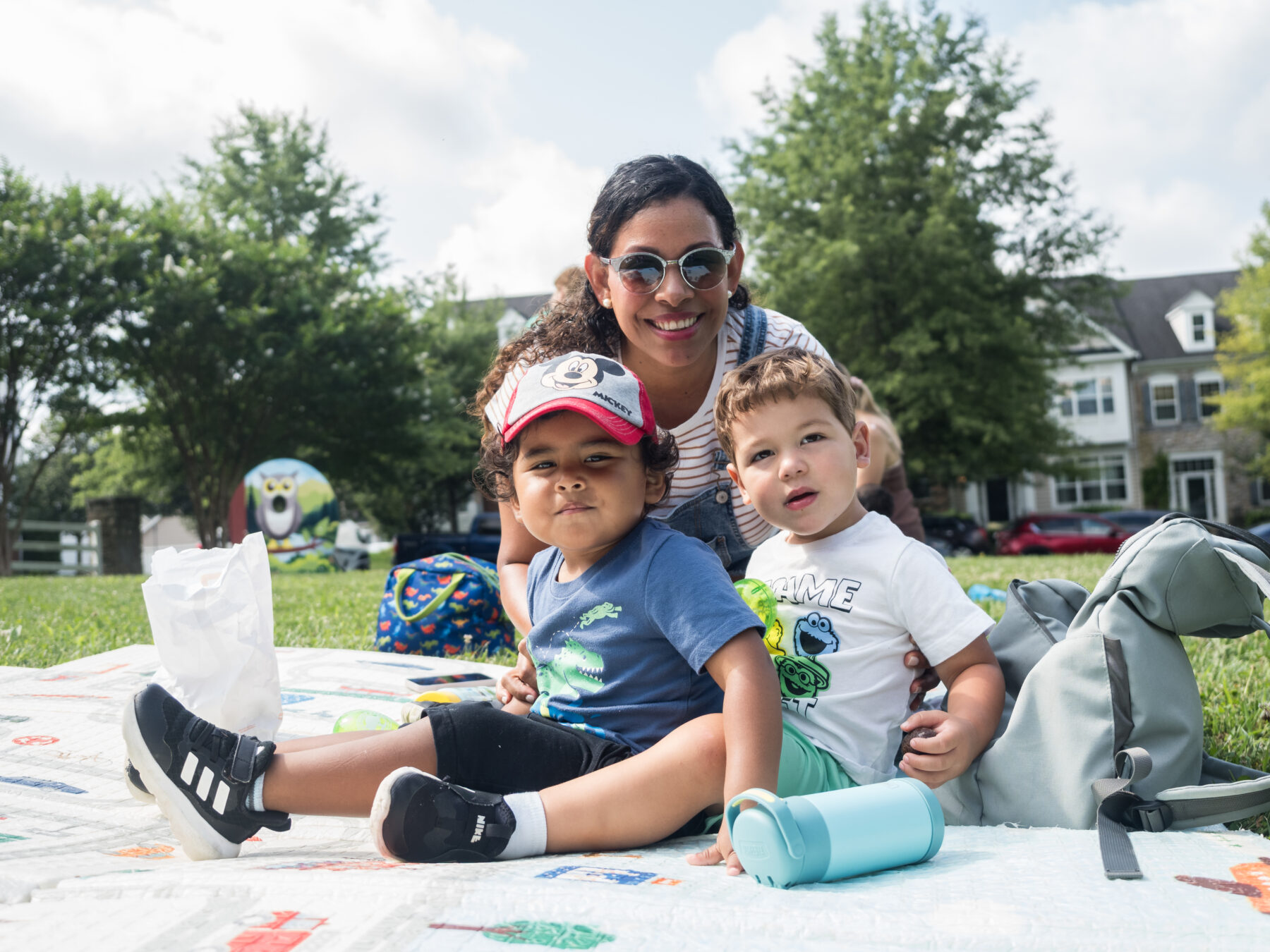 Parent and two young children smile for camera