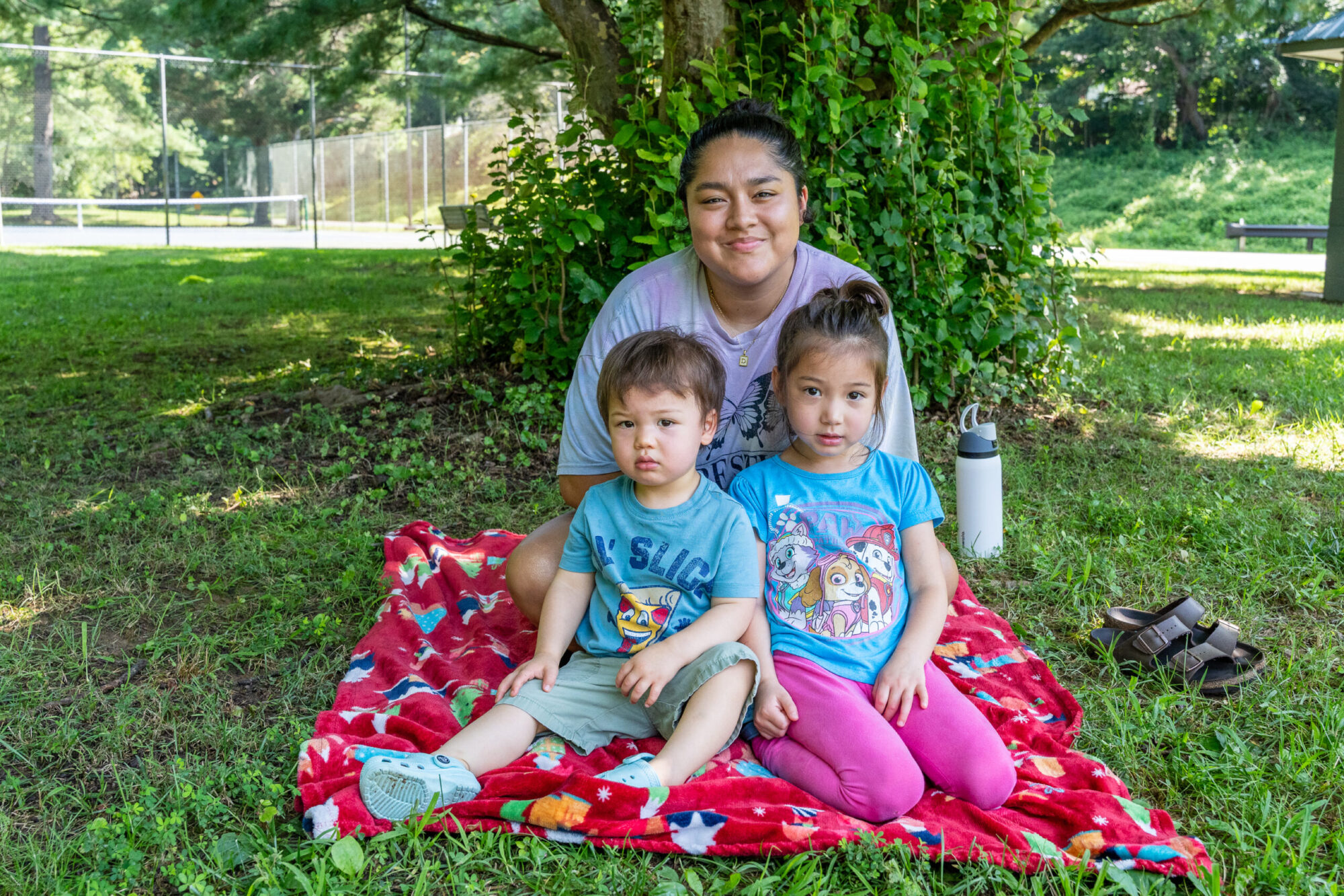 Parent and two child smile for camera on blanket