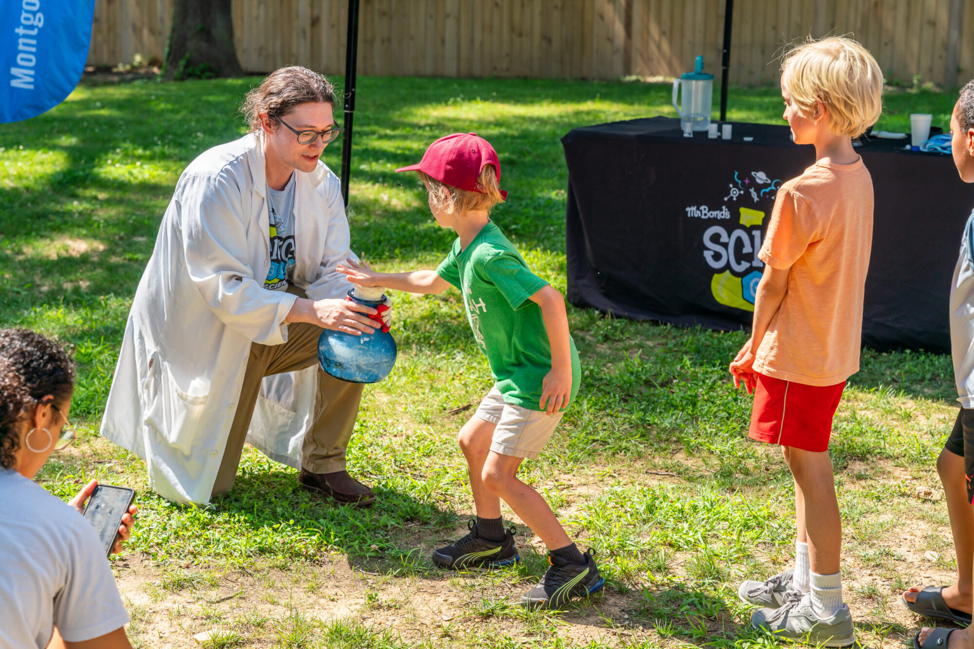 Child presses cap on beaker bottle to help with science experiment