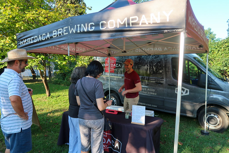 Beer vendor smiles at attendees under tent