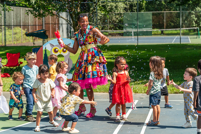 culture queen dances around children with bubbles 