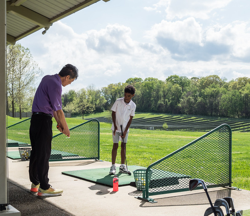 Golf instructor and child at a golf lesson