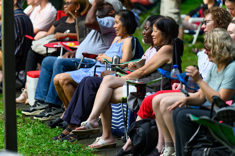 Attendees smile while looking towards the stage
