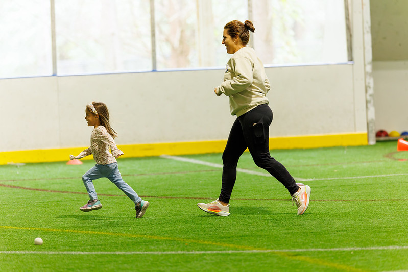 a mom and her daughter running on the turf field at the Wheaton Sports Pavilion