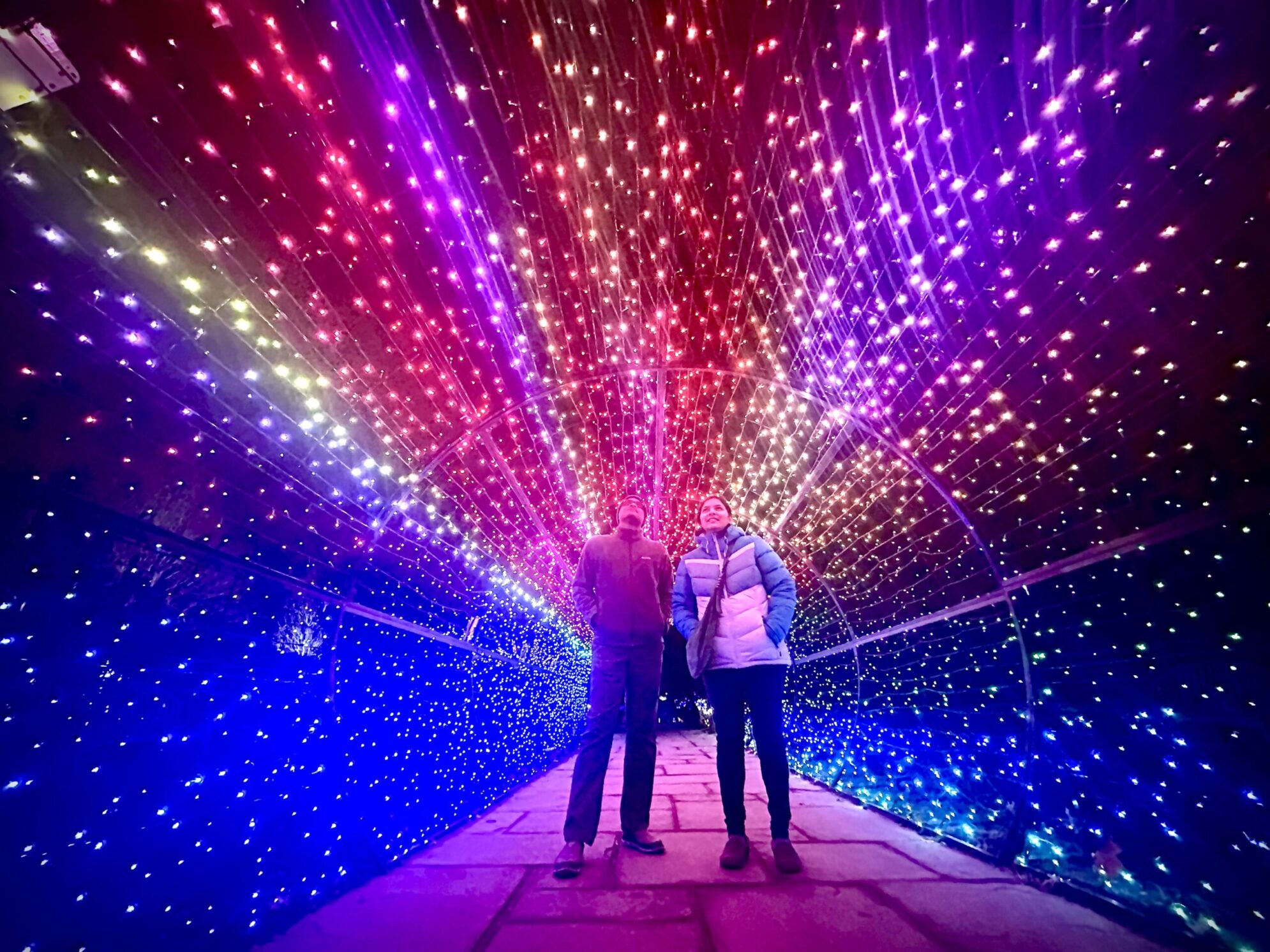Two people enjoying the light tunnel at Garden of Lights