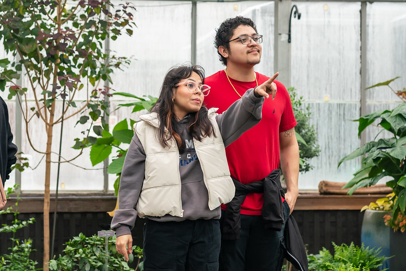 Two people pointing at an unseen butterfly at The Butterfly Experience.