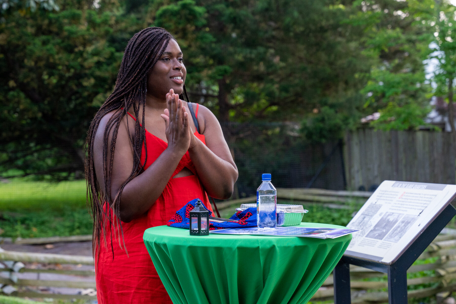 An event guest clapping while standing at a high-top table.