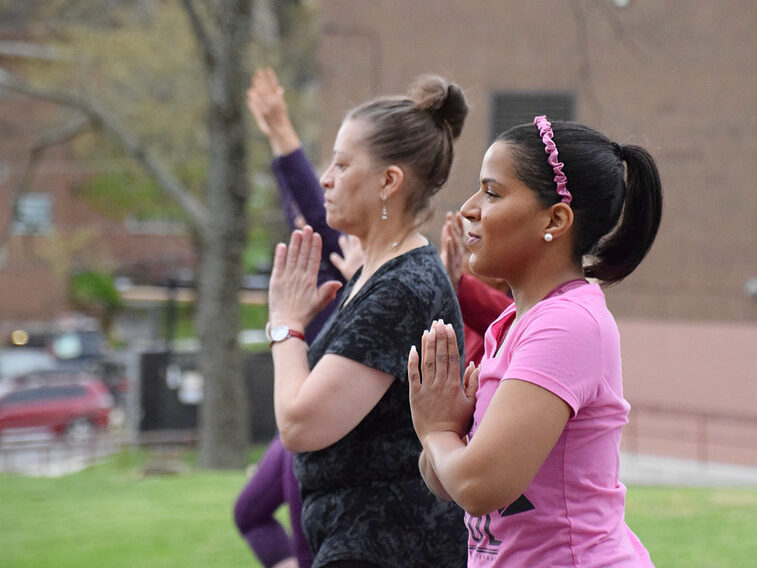 Two women holding a yoga pose at the Sunset Yoga event.