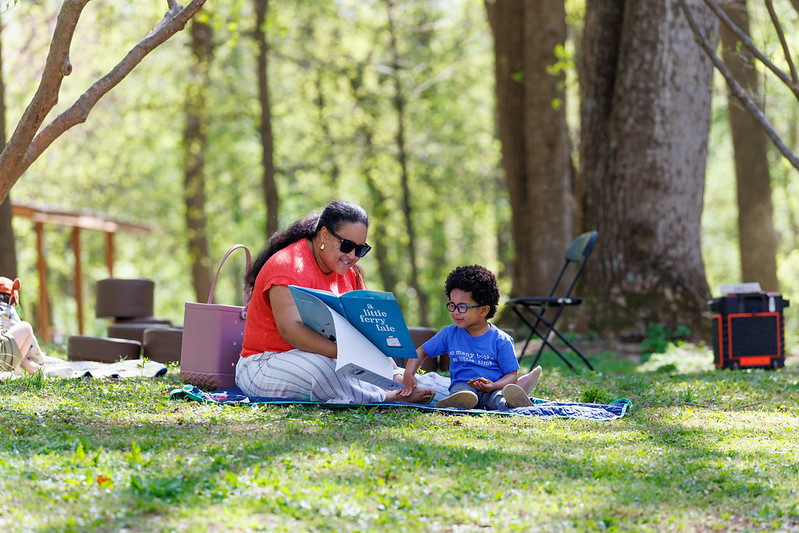 Child-and-caregiver-reading-on-blanket
