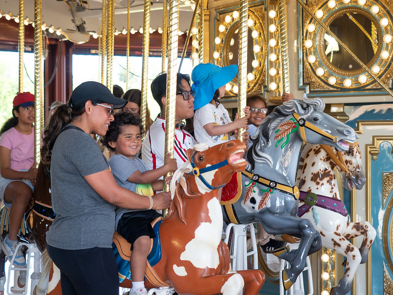 People riding the Ovid Hazen Wells Carousel