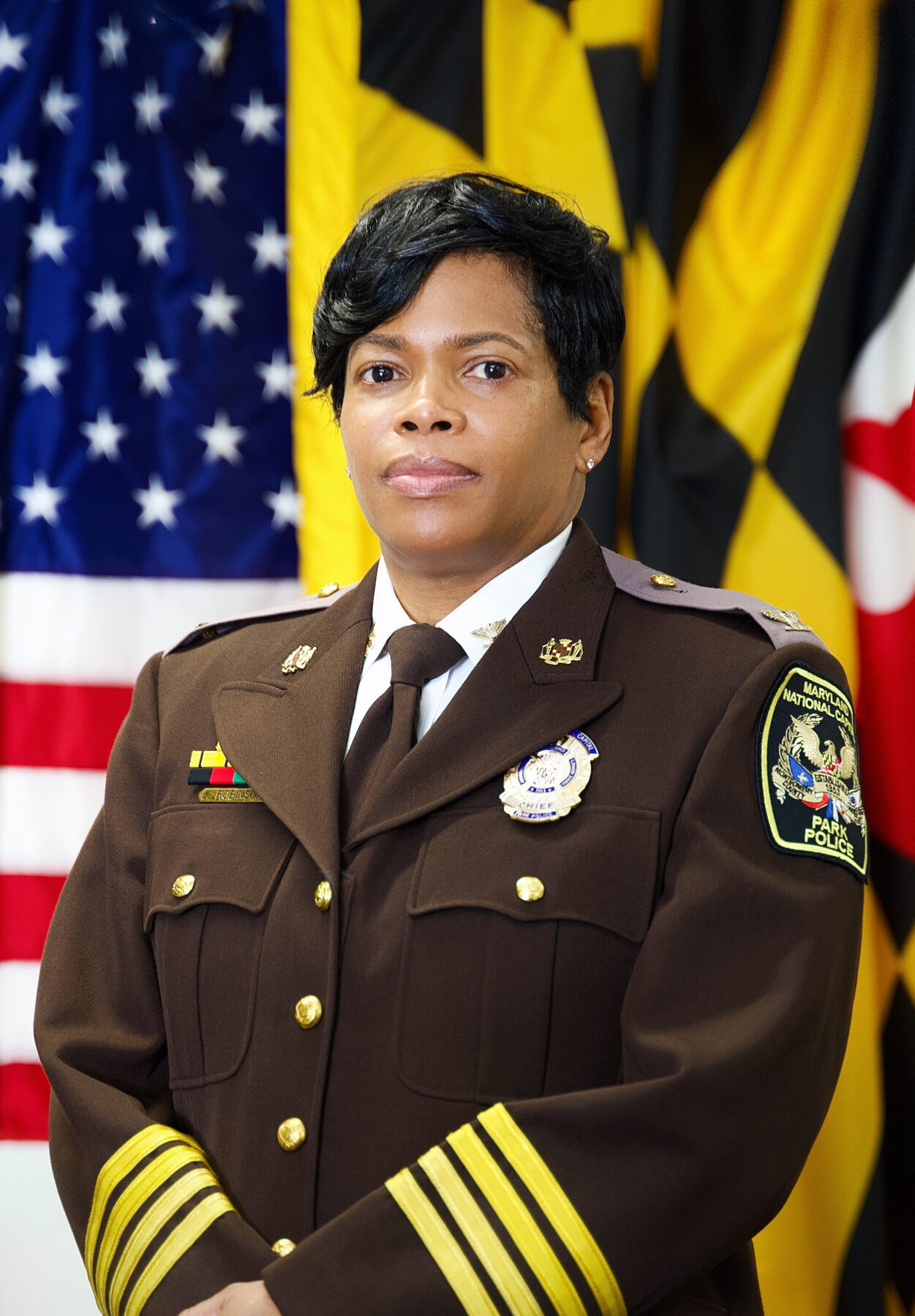 Official Headshot for Police Chief Lakeisha Robinson. Chief Robinson is posing in front of the American and Maryland State flags.