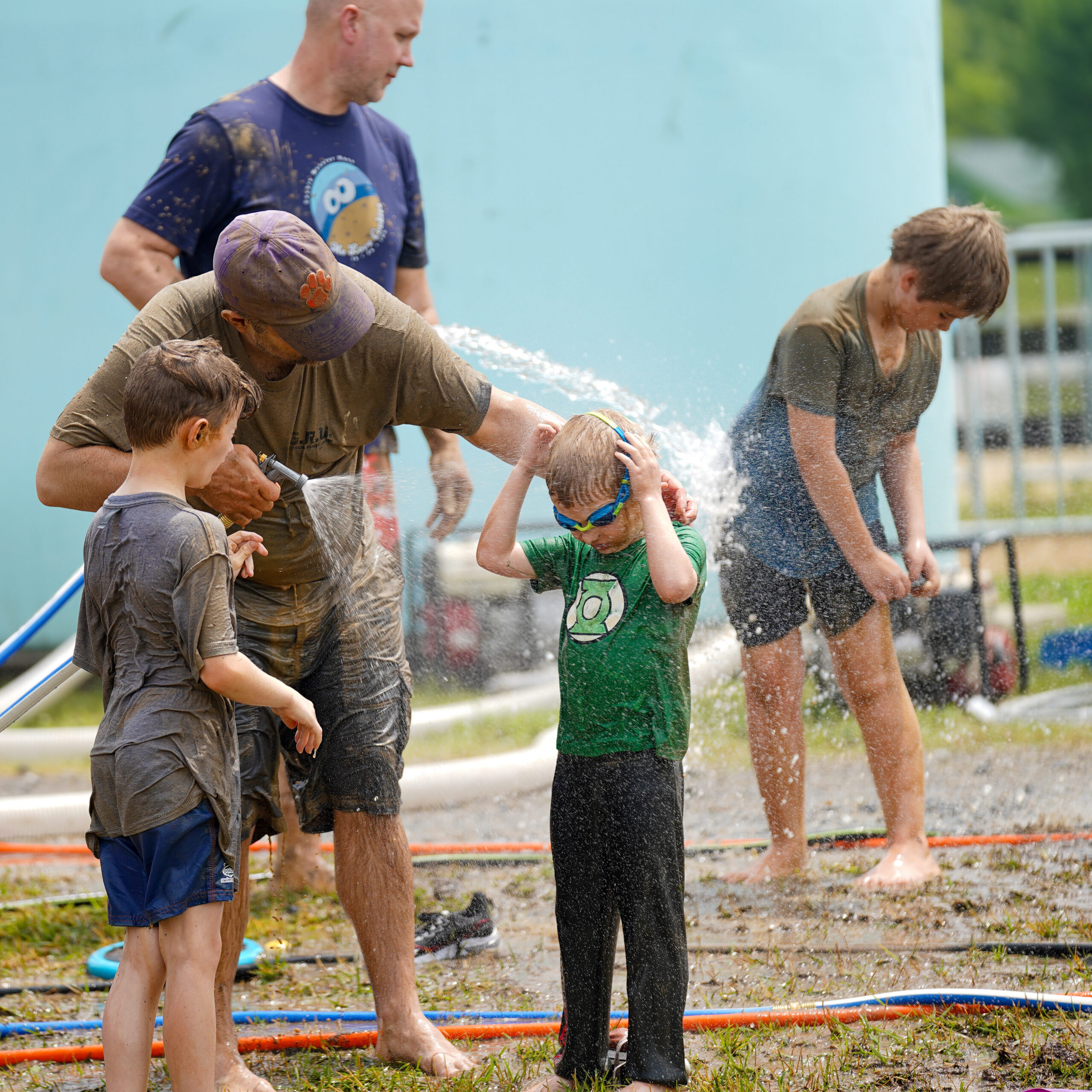 People using hoses to wash off the mud.