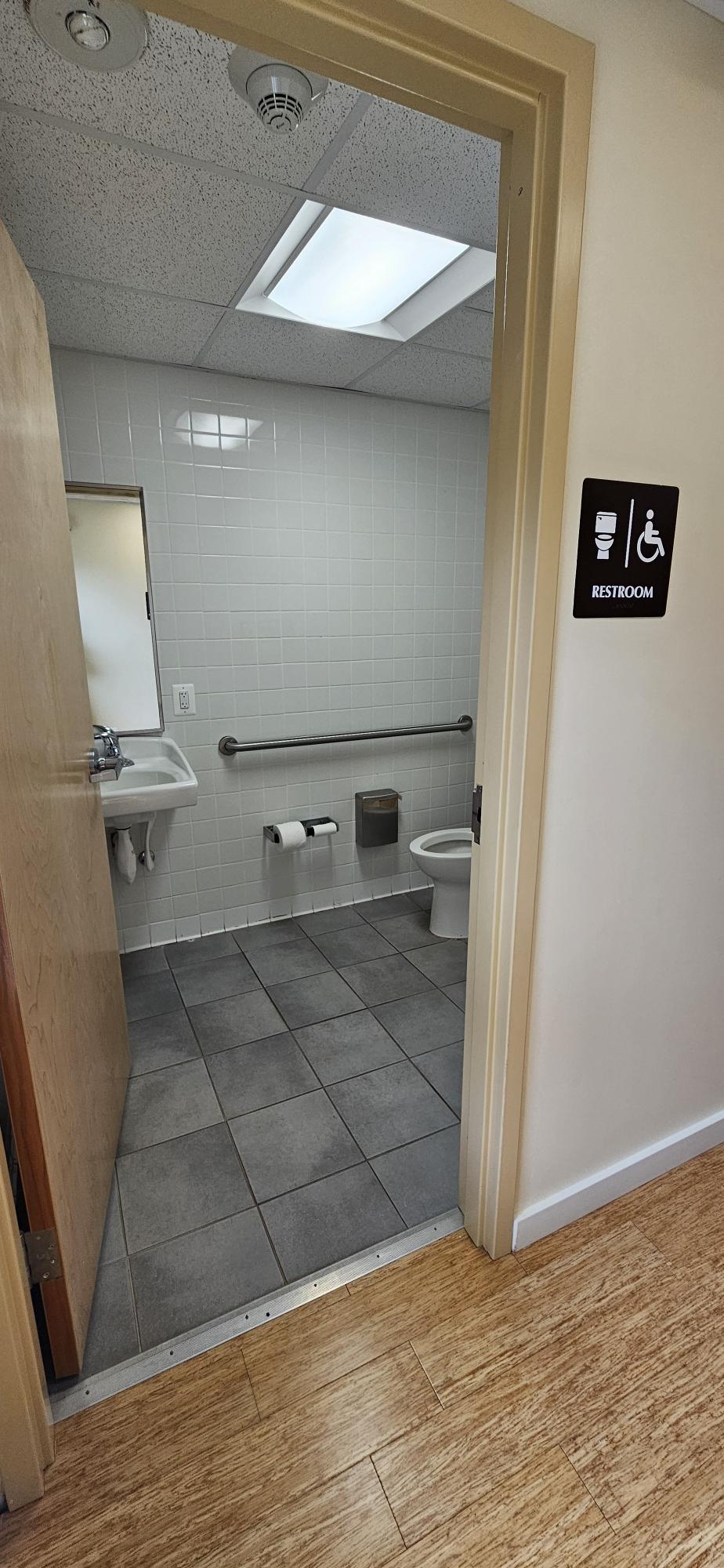 A single accessible bathroom with accessible handrail.
