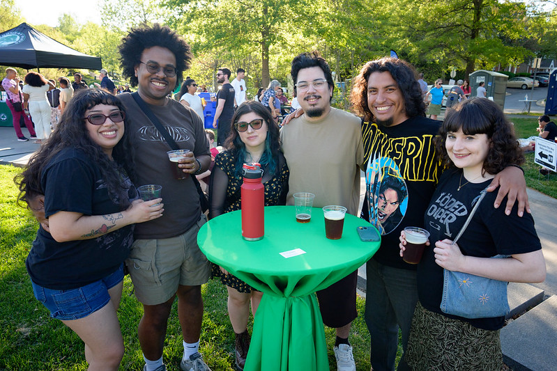 Attendees smile for camera while holding beers