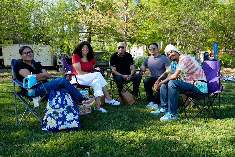 Attendees smile at camera sitting on lawn chairs