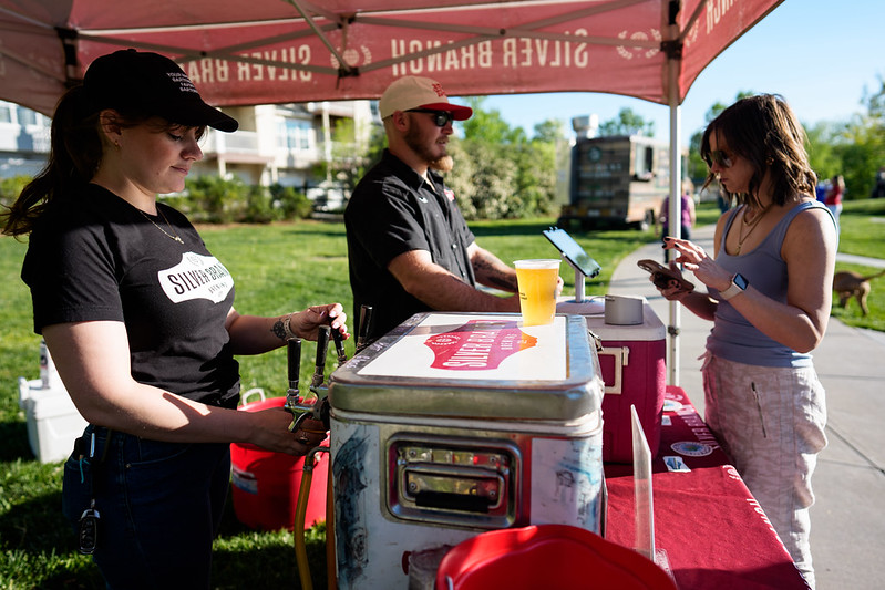 Attendee purchases a beer while vendor pours another beer