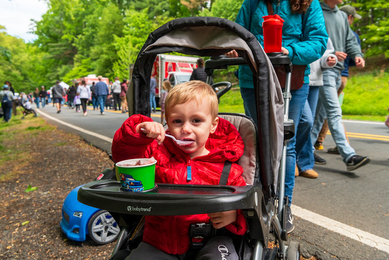 Young child eats ice cream in a stroller