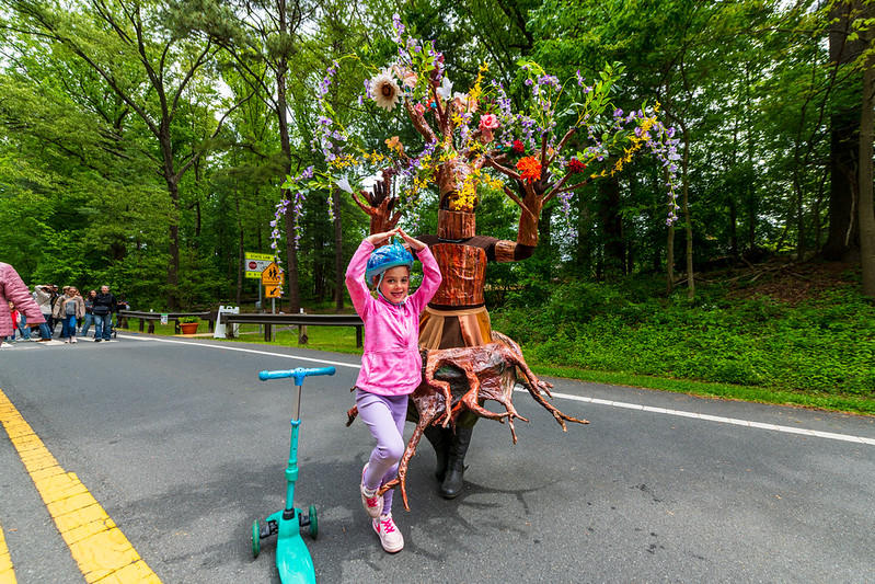 Child poses with vendor dressed as a tree