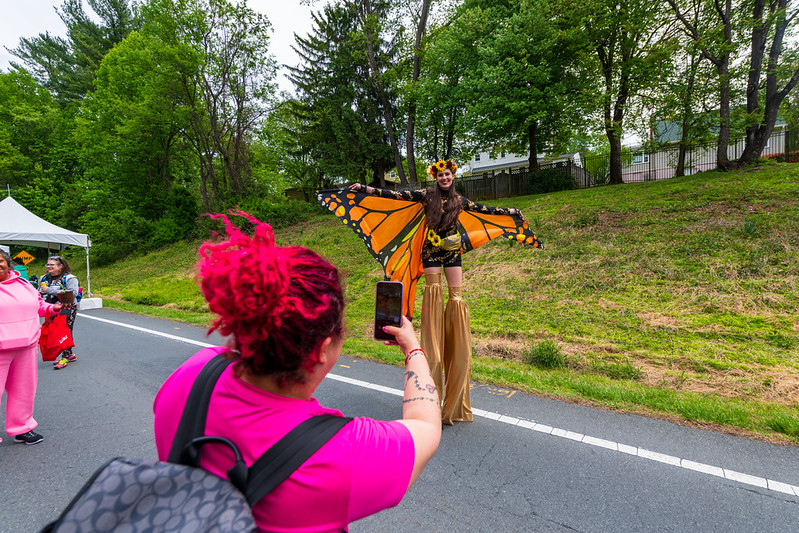 Stilt walker wears orange and black butterfly costume