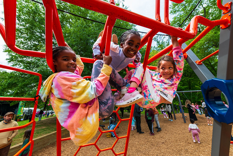 Kids play on playground and smile for camera