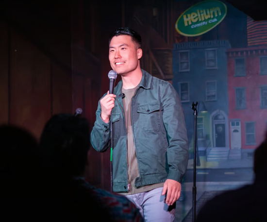 Justin Um hosting comedy show on stage