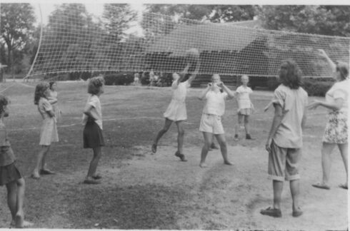 A black and white photo of kids playing volleyball at Kensington Cabin Park